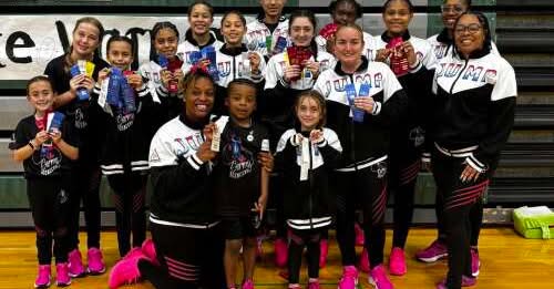 A group of young girls standing next to each other on a basketball court