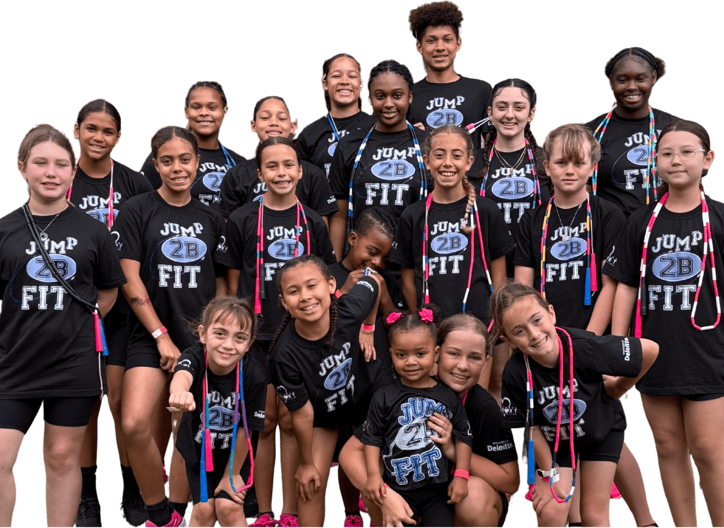 Group of girls in black "Jump 2B Fit" shirts smiling together, showcasing camaraderie and fitness enthusiasm at a community event.
